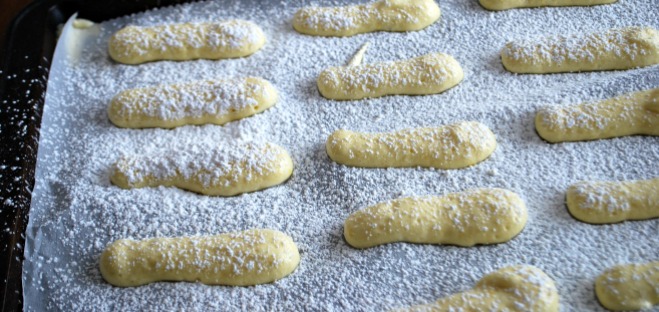 Pipe Lady Fingers in three inch lengths. Dust with powdered sugar before baking.